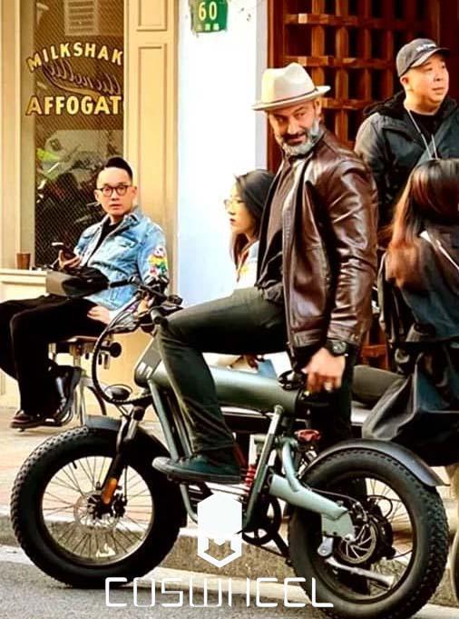 Coswheel electric bike in matte green, side view, city street setting with rider