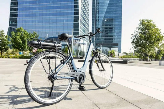 Step-through electric bike in light blue, side view, city background with modern buildings