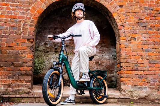 Cyrusher Nova electric bike green side view with rider in urban brick archway setting