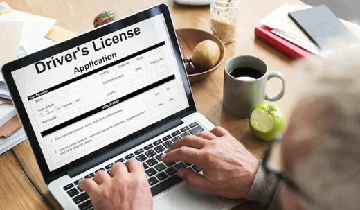 Person applying for a driver's license online using a laptop, close-up view