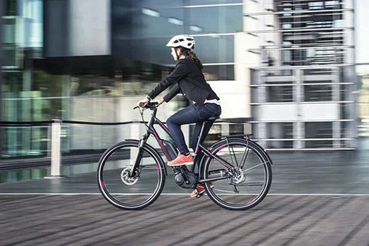 Electric bike commuter riding black e-bike in city, side view