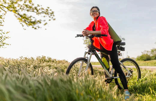 woman with black and silver electric bike in grassy field, city cycling lifestyle scene