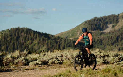 Electric bike ridden on a mountain trail surrounded by green hills and shrubs