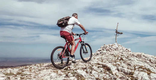 Electric mountain bike in use on rocky terrain with rider and scenic outdoor view