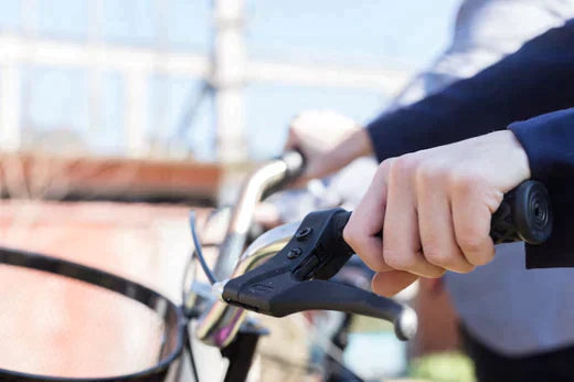 Close-up of electric bike handlebar and brake lever in outdoor urban setting