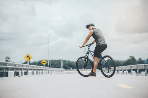 Electric bike with rider on open road, side and rear view, urban commuting setting
