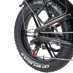 Close-up of a RANDRIDE YX20M-2 Dual Motor Electric motorcycle wheel with chain and 'Randride' branding on a white background